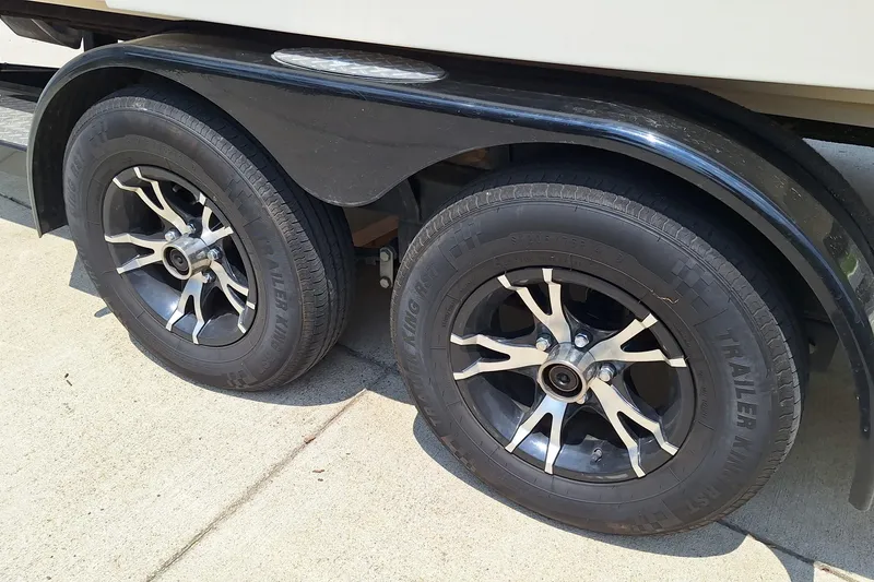 Slide: The Image of Trailer wheels of a 2004 Sea Ray 240 Select boat on a concrete surface. - 11