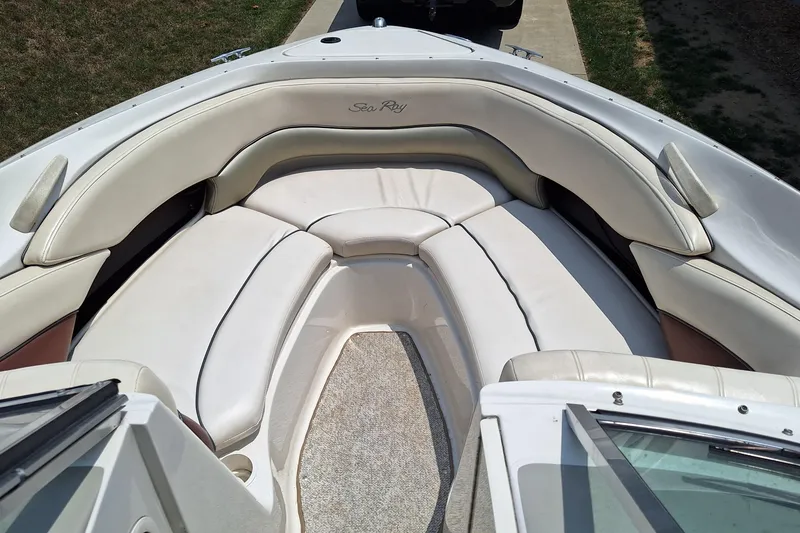 Slide: The Image of 2004 Sea Ray 240 Select boat interior with white cushioned seating and carpeted floor. - 13