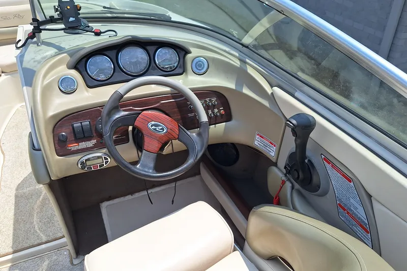 Slide: The Image of 2004 Sea Ray 240 Select boat dashboard with steering wheel and control panel. - 17