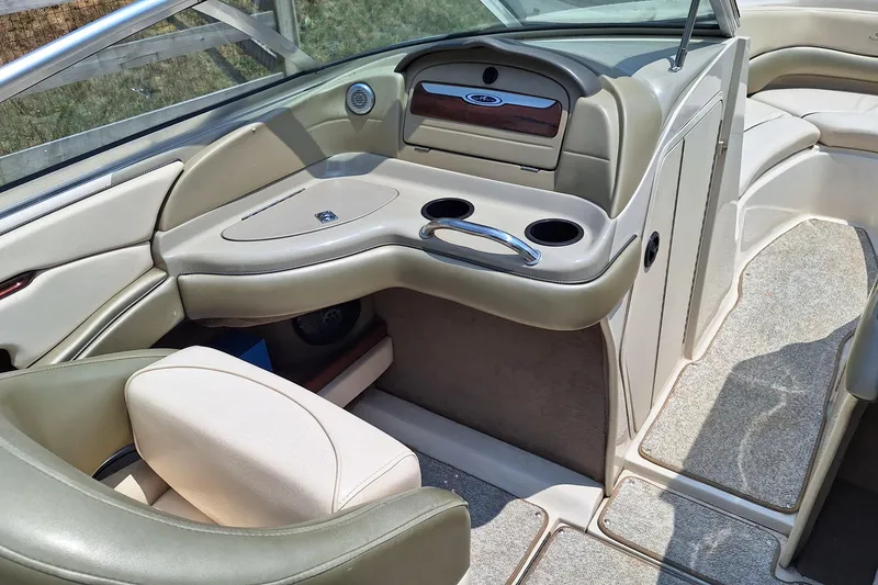 Slide: The Image of Interior of a 2004 Sea Ray 240 Select boat, featuring beige seating and cup holders. - 19