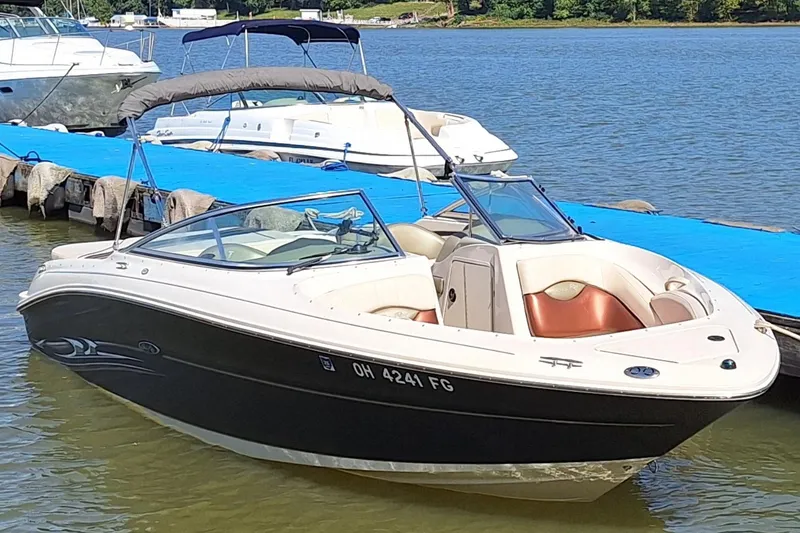 Slide: The Image of 2004 Sea Ray 240 Select boat docked on a sunny day by the water. - 27