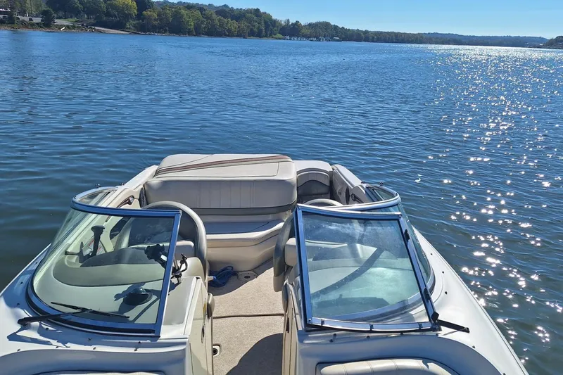 Slide: The Image of 2004 Sea Ray 240 Select boat on a sunny lake, showcasing open seating and clear water. - 29