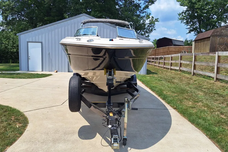 Slide: The Image of 2004 Sea Ray 240 Select boat on trailer, parked near a metal shed. - 3