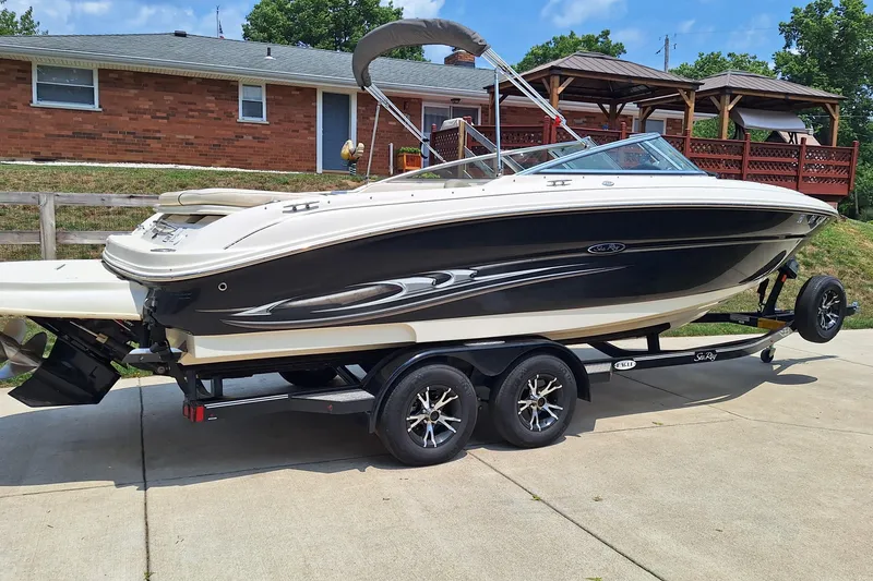 Slide: The Image of 2004 Sea Ray 240 Select boat on trailer, parked in driveway near brick house. - 4