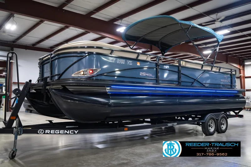 Slide: The Image of 2018 Regency 254 DL3 pontoon boat on trailer in indoor showroom. - 2