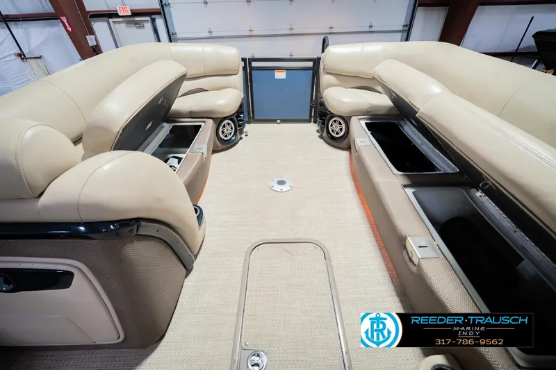 Slide: The Image of Interior of a 2018 Regency 254 DL3 pontoon boat with beige seating and storage compartments. - 26