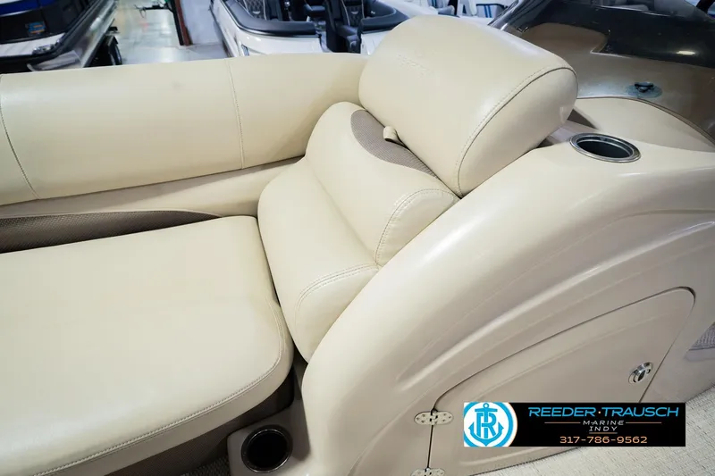 Slide: The Image of 2018 Regency 254 DL3 boat interior with beige seating and cup holder. - 28