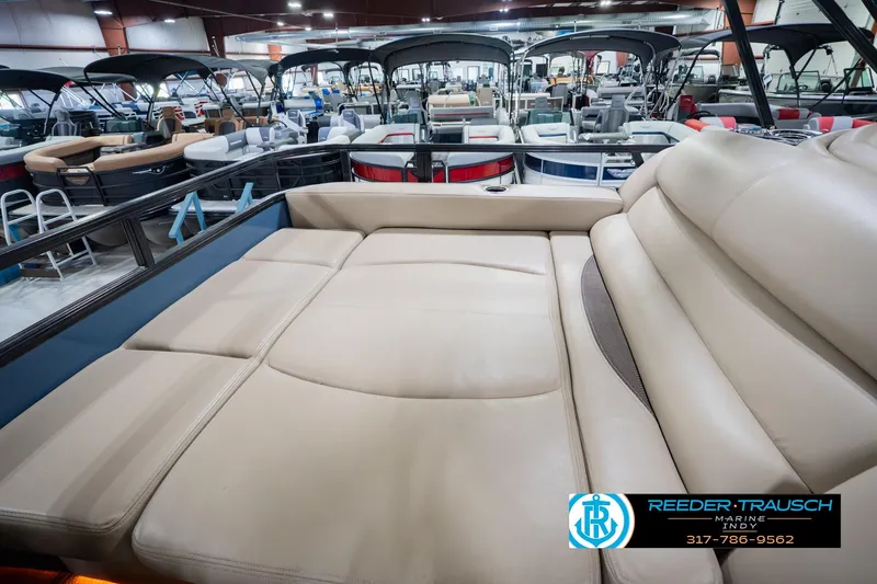 Slide: The Image of 2018 Regency 254 DL3 pontoon boat interior with beige seating in showroom. - 35
