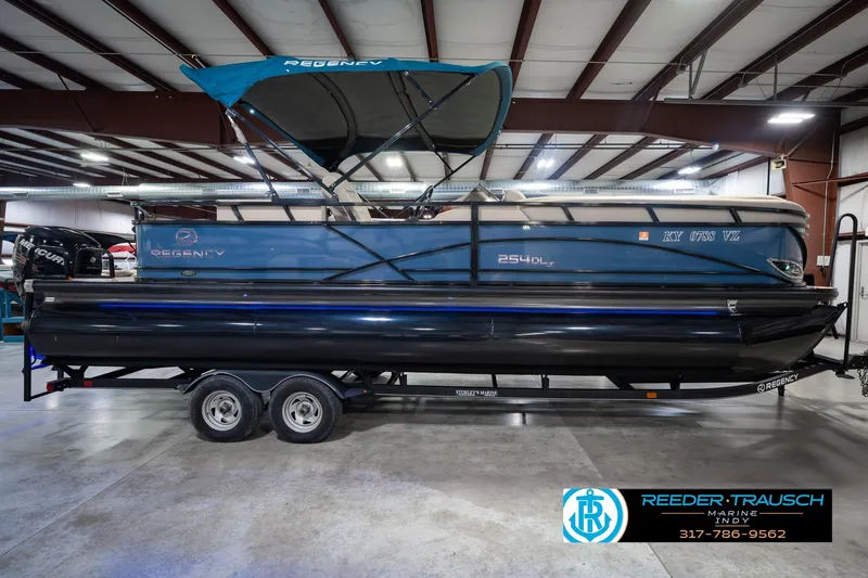 Slide: The Image of 2018 Regency 254 DL3 pontoon boat on trailer in indoor showroom. - 6