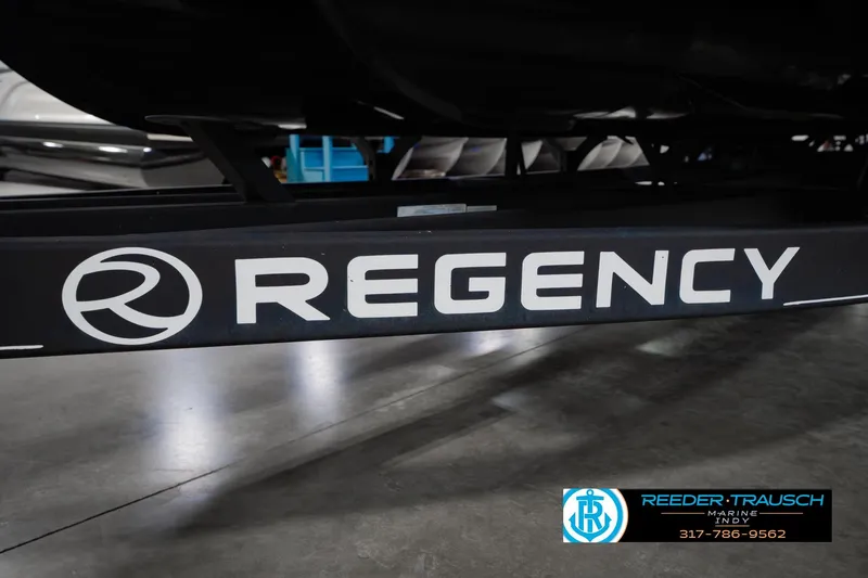 Slide: The Image of 2018 Regency 254 DL3 boat trailer with logo in a showroom setting. - 65
