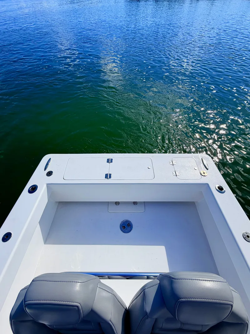 Slide: The Image of Aft view of a 1973 Custom Carolina 27 National boat on calm water. - 42