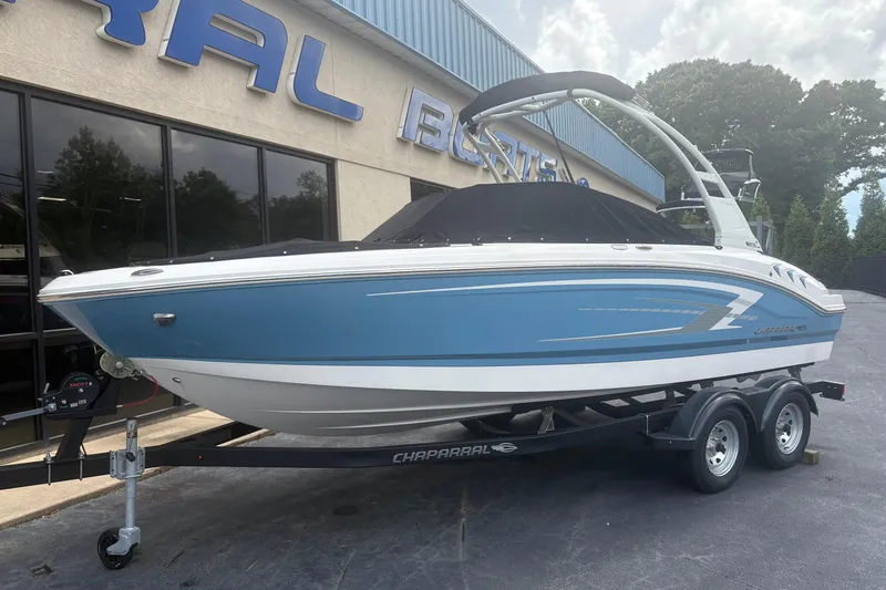 The Image of 2026 Chaparral 21 SSi boat in blue on trailer, parked outside dealership. - 0