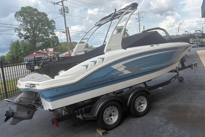 Slide: The Image of 2026 Chaparral 21 SSi boat on trailer, blue and white design, parked outdoors. - 1