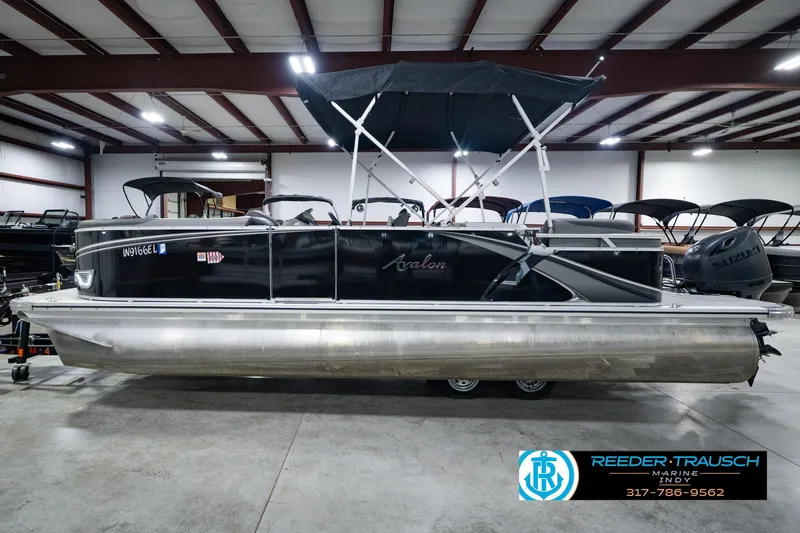 Slide: The Image of 2025 Avalon 2385 LSZ ENT pontoon boat in showroom, featuring sleek design and canopy. - 12