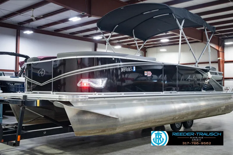 Slide: The Image of 2025 Avalon 2385 LSZ ENT pontoon boat in showroom with canopy and sleek design. - 2