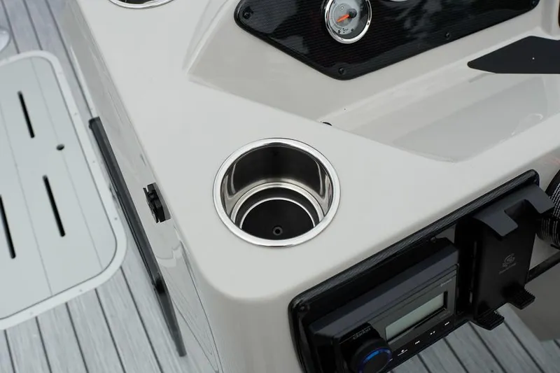 Slide: The Image of 2026 SunCatcher Select 322SL boat console with cup holders and control panel. - 20