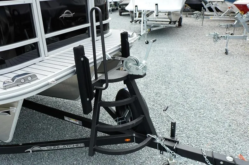 Slide: The Image of 2026 SunCatcher Select 322SL boat trailer with winch on gravel surface. - 42