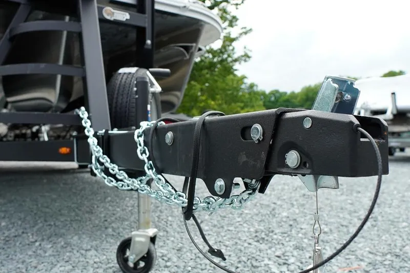Slide: The Image of Trailer hitch of 2026 SunCatcher Select 322SL boat on gravel surface. - 45