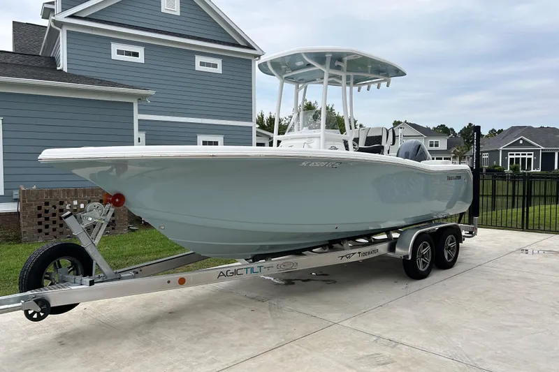 Slide: The Image of 2023 Tidewater 220 LXF boat on trailer in residential driveway. - 3