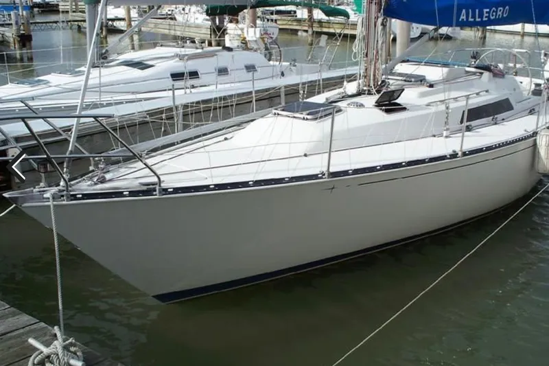 The Image of 1983 C&C 35 sailboat docked in marina, featuring sleek design and white hull. - 1