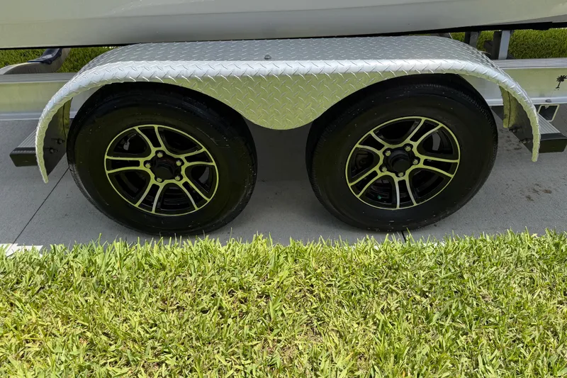 Slide: The Image of Trailer wheels of 2023 Tidewater 198 CC Adventure boat on grass. - 15