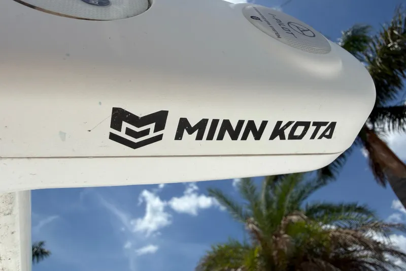 Slide: The Image of Minn Kota motor on 2023 Tidewater 198 CC Adventure boat, with palm trees and blue sky background. - 22