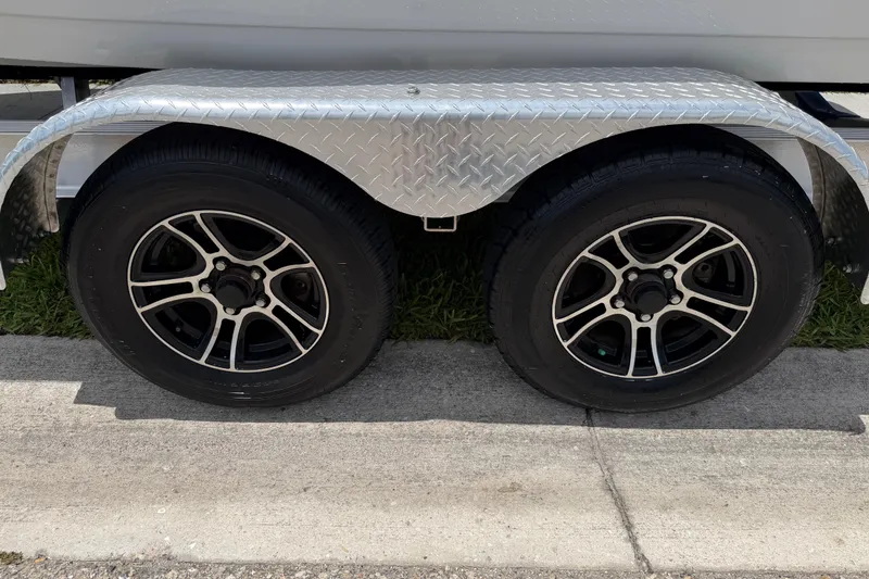 Slide: The Image of Trailer wheels of 2023 Tidewater 198 CC Adventure boat on pavement. - 26