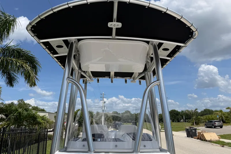 Slide: The Image of 2023 Tidewater 198 CC Adventure boat with T-top, parked on a sunny street. - 54