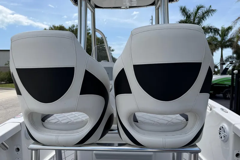 Slide: The Image of 2023 Tidewater 198 CC Adventure boat seats, white and black design, outdoor setting. - 85