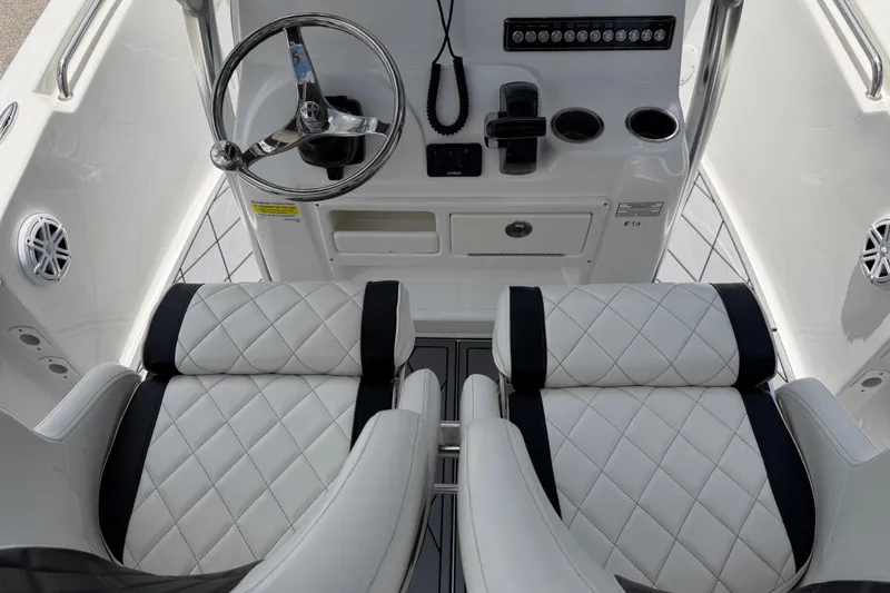 Slide: The Image of 2023 Tidewater 198 CC Adventure boat interior with steering wheel and cushioned seats. - 88
