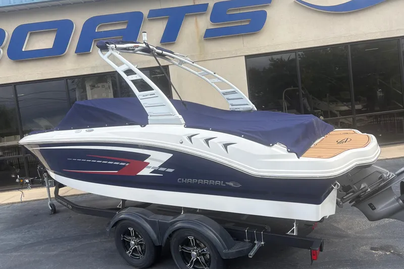 The Image of 2025 Chaparral 21 SSi boat with cover on trailer, parked outside dealership. - 0
