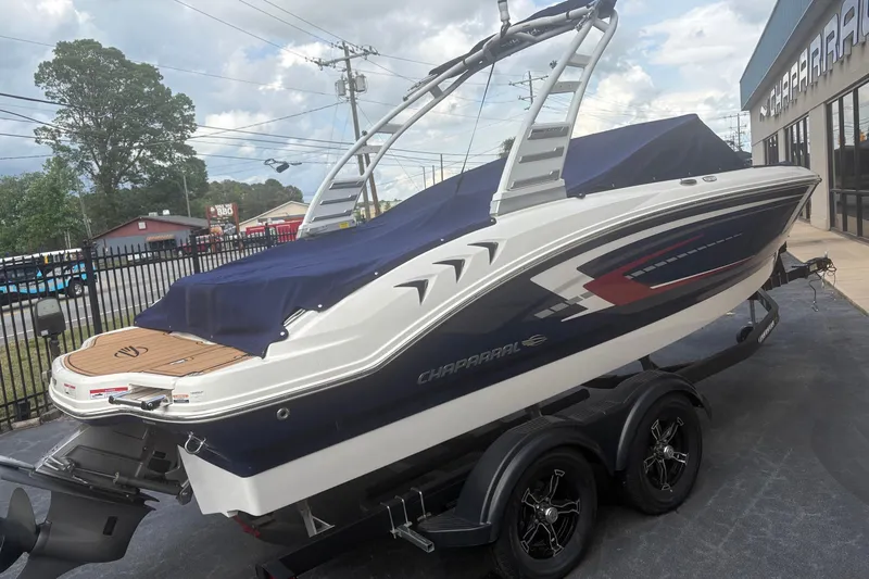 Slide: The Image of 2025 Chaparral 21 SSi boat on trailer, covered and parked outdoors. - 2