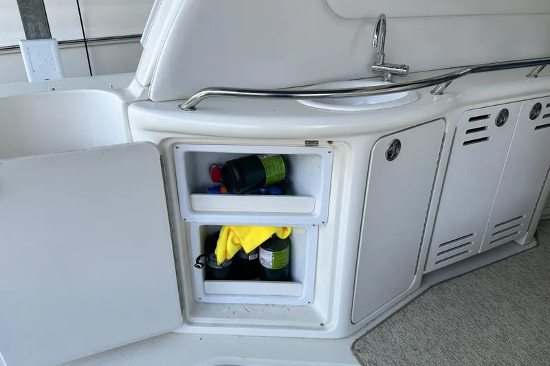 Slide: The Image of 2001 Sea Ray 410 Sundancer boat kitchenette with open storage and sink. - 10