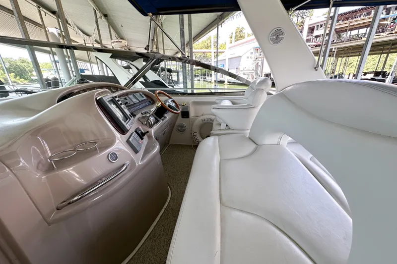 Slide: The Image of Interior of 2001 Sea Ray 410 Sundancer yacht with white seating and control panel. - 15