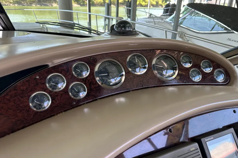 Slide: The Image of Dashboard of a 2001 Sea Ray 410 Sundancer boat with multiple gauges and compass. - 19