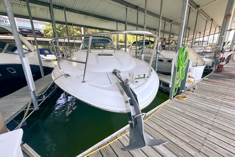 Slide: The Image of 2001 Sea Ray 410 Sundancer yacht docked in a marina under a covered shelter. - 2