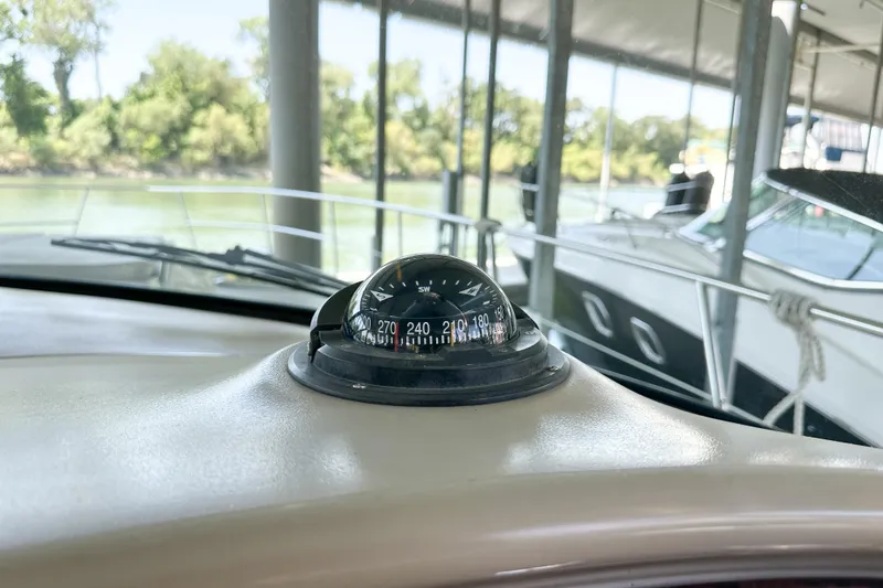 Slide: The Image of Compass on 2001 Sea Ray 410 Sundancer boat dashboard, docked near trees. - 20