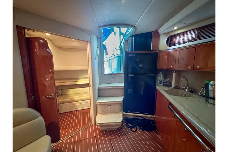 Slide: The Image of Interior of 2001 Sea Ray 410 Sundancer yacht with kitchenette and seating area. - 22