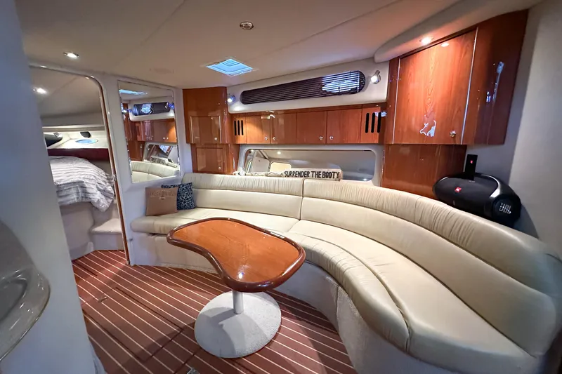 Slide: The Image of Luxurious interior of 2001 Sea Ray 410 Sundancer yacht with curved seating and wooden cabinetry. - 23