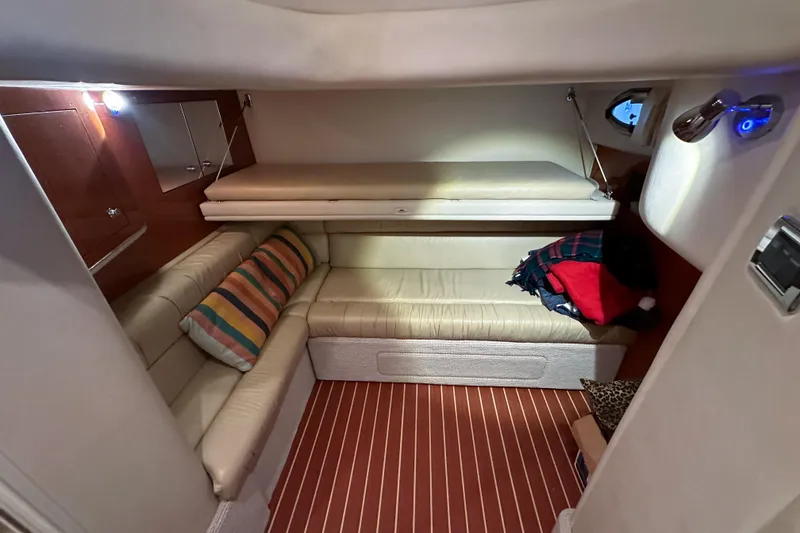 Slide: The Image of Interior cabin of 2001 Sea Ray 410 Sundancer with beige seating and striped cushions. - 24