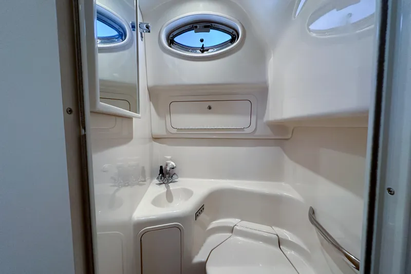 Slide: The Image of Compact bathroom in a 2001 Sea Ray 410 Sundancer yacht, featuring a sink and porthole window. - 30