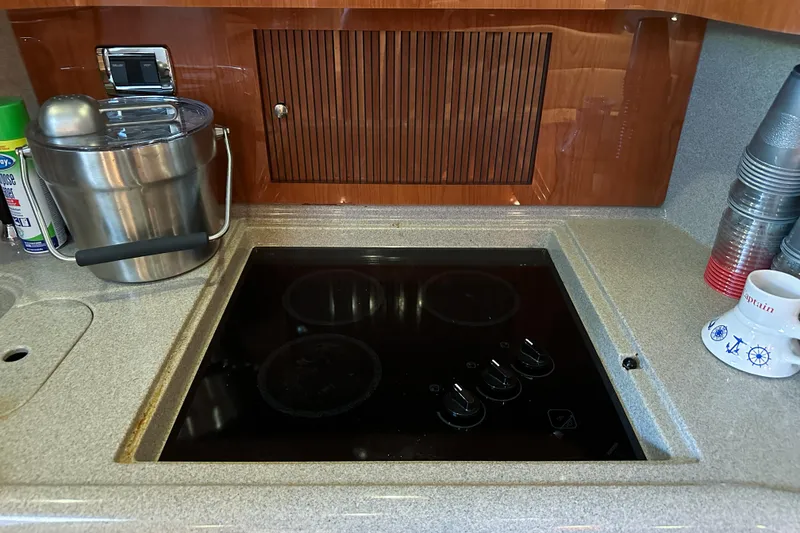 Slide: The Image of Galley kitchen in 2001 Sea Ray 410 Sundancer with stovetop and countertop accessories. - 31