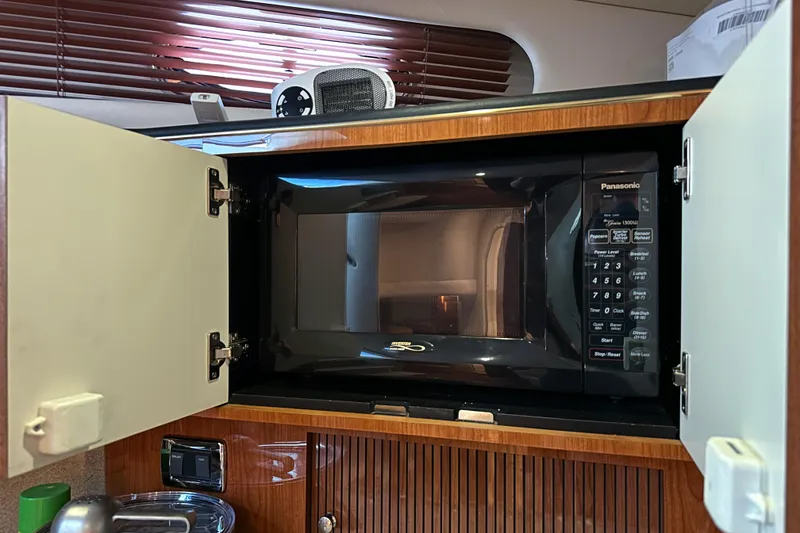 Slide: The Image of Microwave in 2001 Sea Ray 410 Sundancer yacht kitchen, with open cabinet doors. - 32