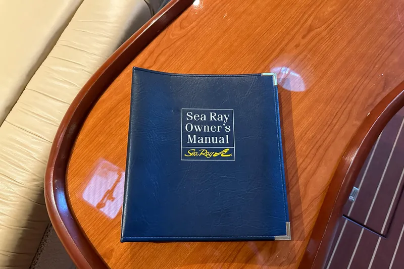 Slide: The Image of Sea Ray 410 Sundancer 2001 owner's manual on wooden table. - 35