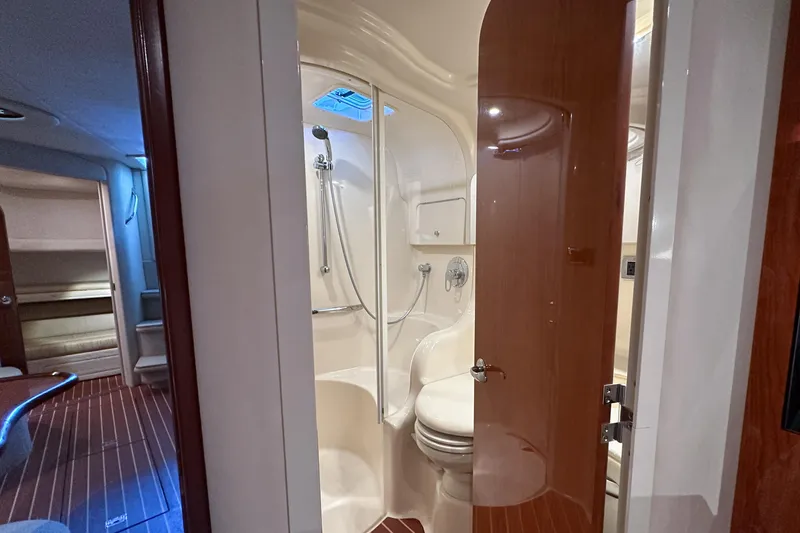 Slide: The Image of Interior of 2001 Sea Ray 410 Sundancer yacht, featuring a compact bathroom with shower. - 37