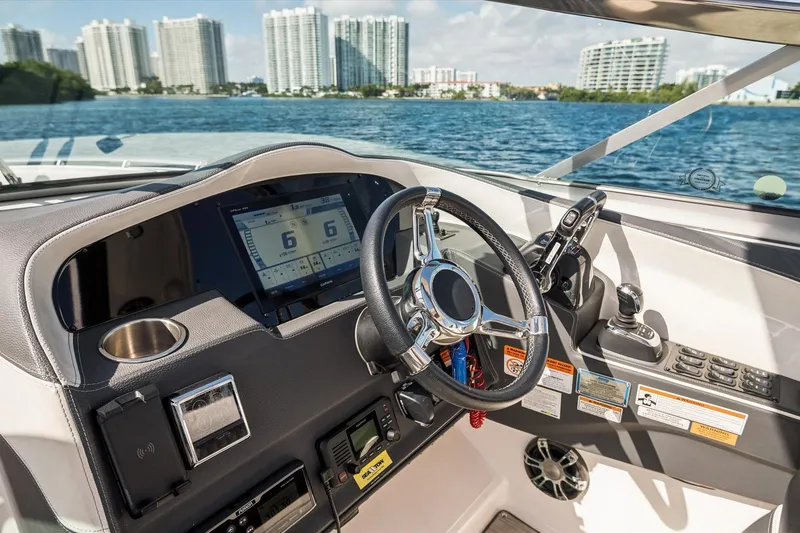 Slide: The Image of 2019 Regal 33 OBX boat helm with modern controls and waterfront view. - 16