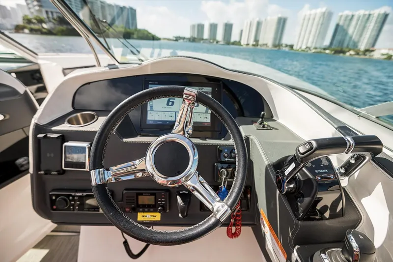 Slide: The Image of Cockpit of 2019 Regal 33 OBX boat with steering wheel and control panel. - 17
