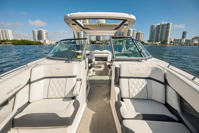 Slide: The Image of 2019 Regal 33 OBX boat interior with luxury seating, cruising near city skyline. - 20
