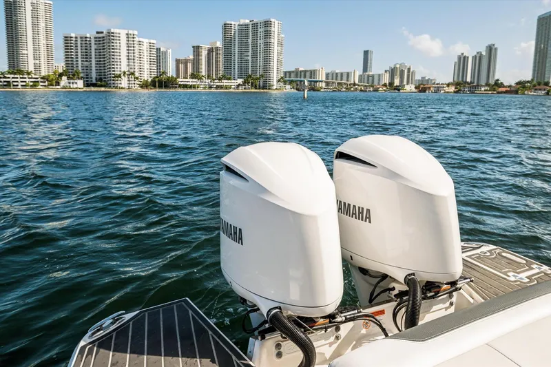 Slide: The Image of 2019 Regal 33 OBX boat with twin Yamaha outboard engines on a city waterfront. - 25
