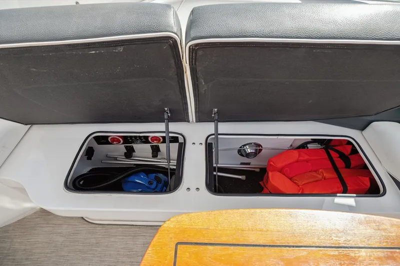 Slide: The Image of Storage compartments on a 2019 Regal 33 OBX boat, featuring life jackets and equipment. - 28